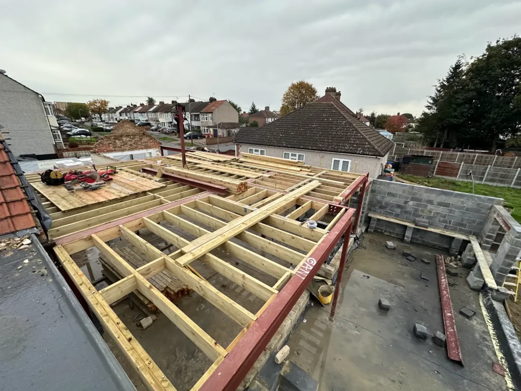 Timber joists supported by red steel beams, viewed from above the Hornchurch building site